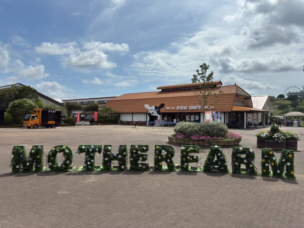 青空の下にあるマザー牧場の「MOTHER FARM」モニュメントとまきばCAFE